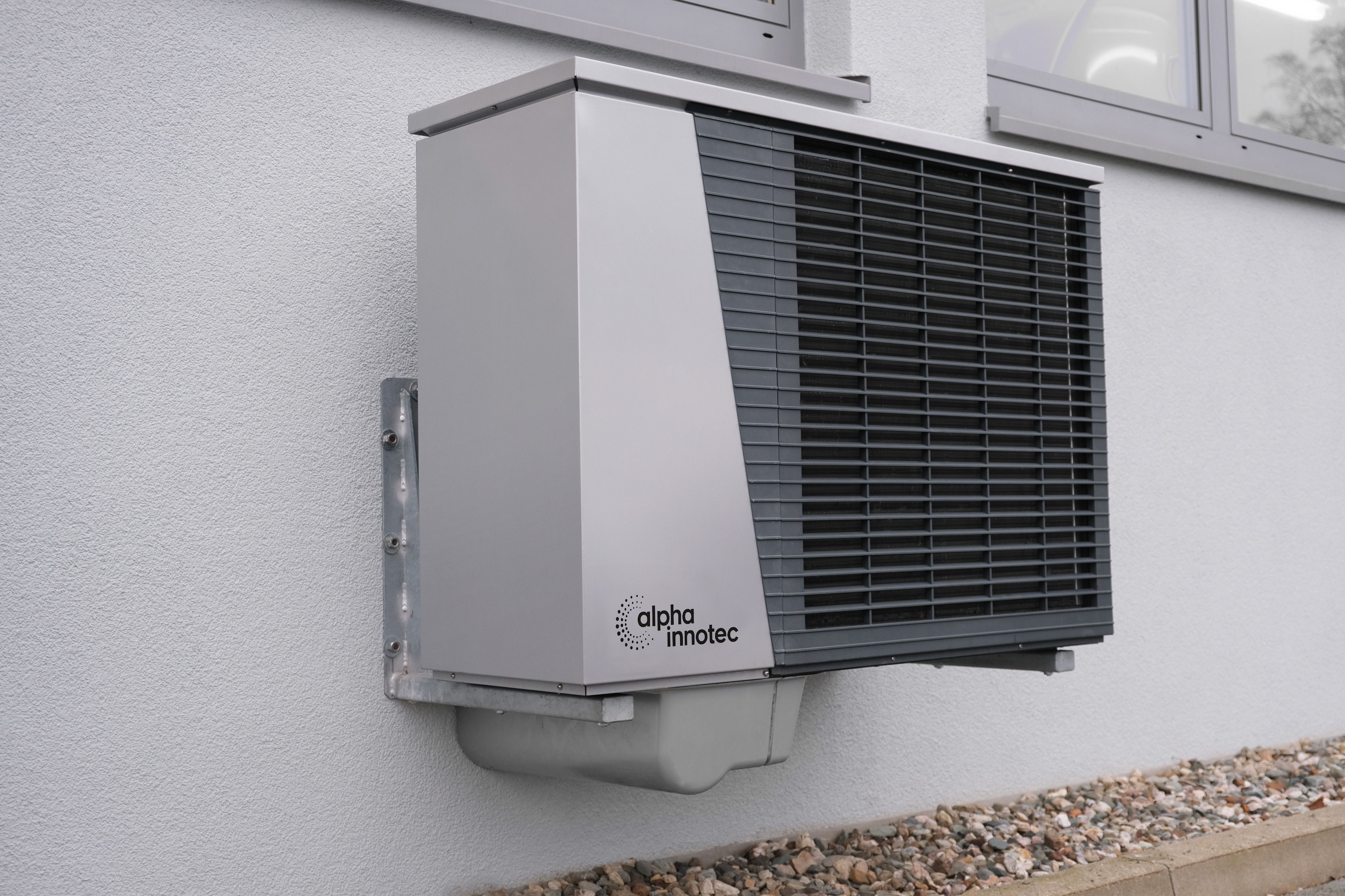 A modern heat pump outdoor unit installed neatly on the wall of an Auckland home